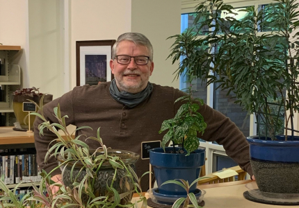 man standing behind a shelf 