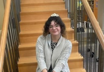 Photo of Carnita Dominguez, sitting on steps of stairs