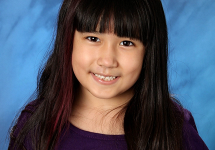 A school picture of a young girl with bangs and long dark hair