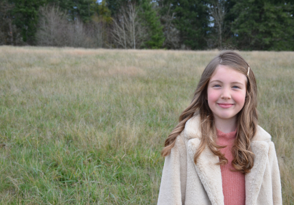 A girl standing out in a field. 