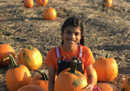 Picture of a girl in a pumpkin field.