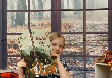 Picture of a girl holding a book on a daybed