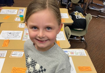 Madelyn standing next to a chair and table