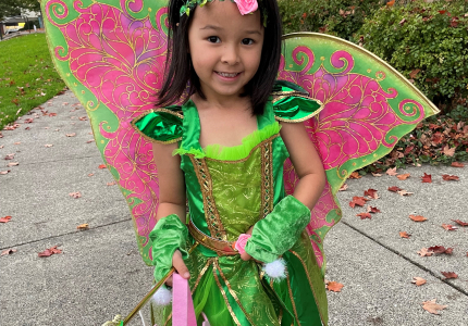 Emma standing in front of the library wearing a garden fairy costume.