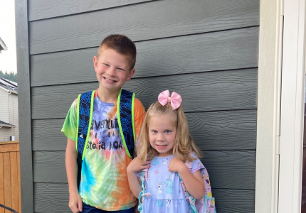 Skyler and Madison standing next to each other wearing backpacks