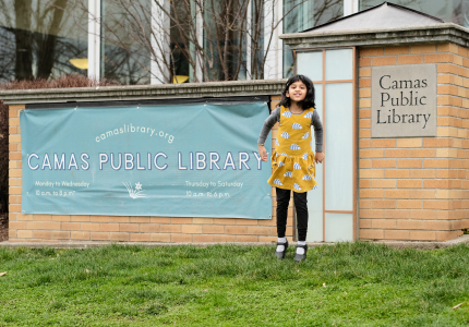 Diya jumping next to the library's 4th Ave sign