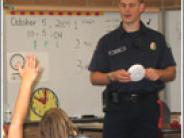 Fire fighter leading a class with children