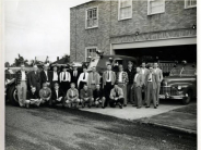 photo 22 people from the fire department in front of 3 1950's era fire engines outside brick building