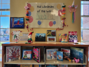 Closeup of books and art on display on bookshelves