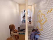 Discovery Hallway featuring an interactive wall with spinning balls and children playing.