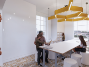 STEAM Studio with a drawable whiteboard surface, children working at tables, and large windows providing natural light.