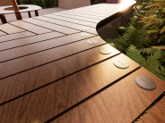 Curved wooden bench in the Camas Public Library courtyard featuring donor name plaques