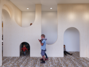 Discovery Hallway with children exploring curved cutouts and crawl spaces in a creative play environment.