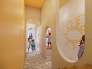 Discovery Hallway with children exploring curved cutouts and crawl spaces in a creative play environment.