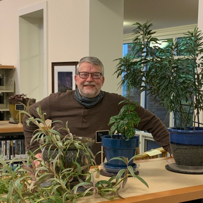 man standing behind a shelf 