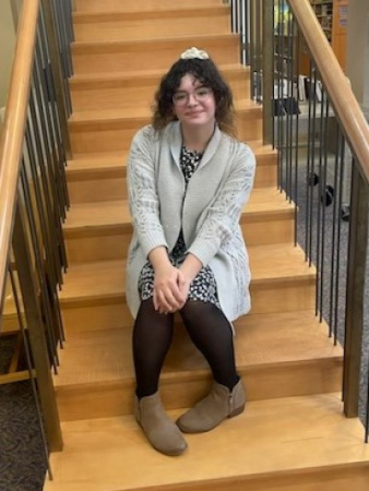 Photo of Carnita Dominguez, sitting on steps of stairs