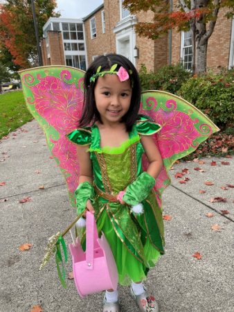 Emma standing in front of the library wearing a garden fairy costume.