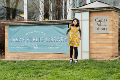 Diya jumping next to the library's 4th Ave sign